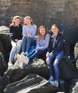 Girls on boulders Arromanches beach